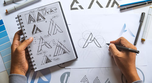 person drawing a logo sketch of the letter A